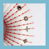 présentation de bracelets gigi clozeau en or 18 carats. Bracelet classique gigi clozeau or 18 carats couleur corail. Bracelet gigi clozeau croix vintage or 18 carats de couleur corail. Bracelet lucky trèfle gigi clozeau en or 18 carats.