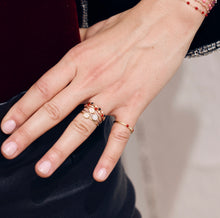 Photo de la main d’une femme portant plusieurs bagues Gigi Clozeau.