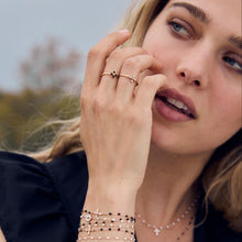 Photo de la main d'une femme, portant plusieurs bagues Gigi Clozeau.