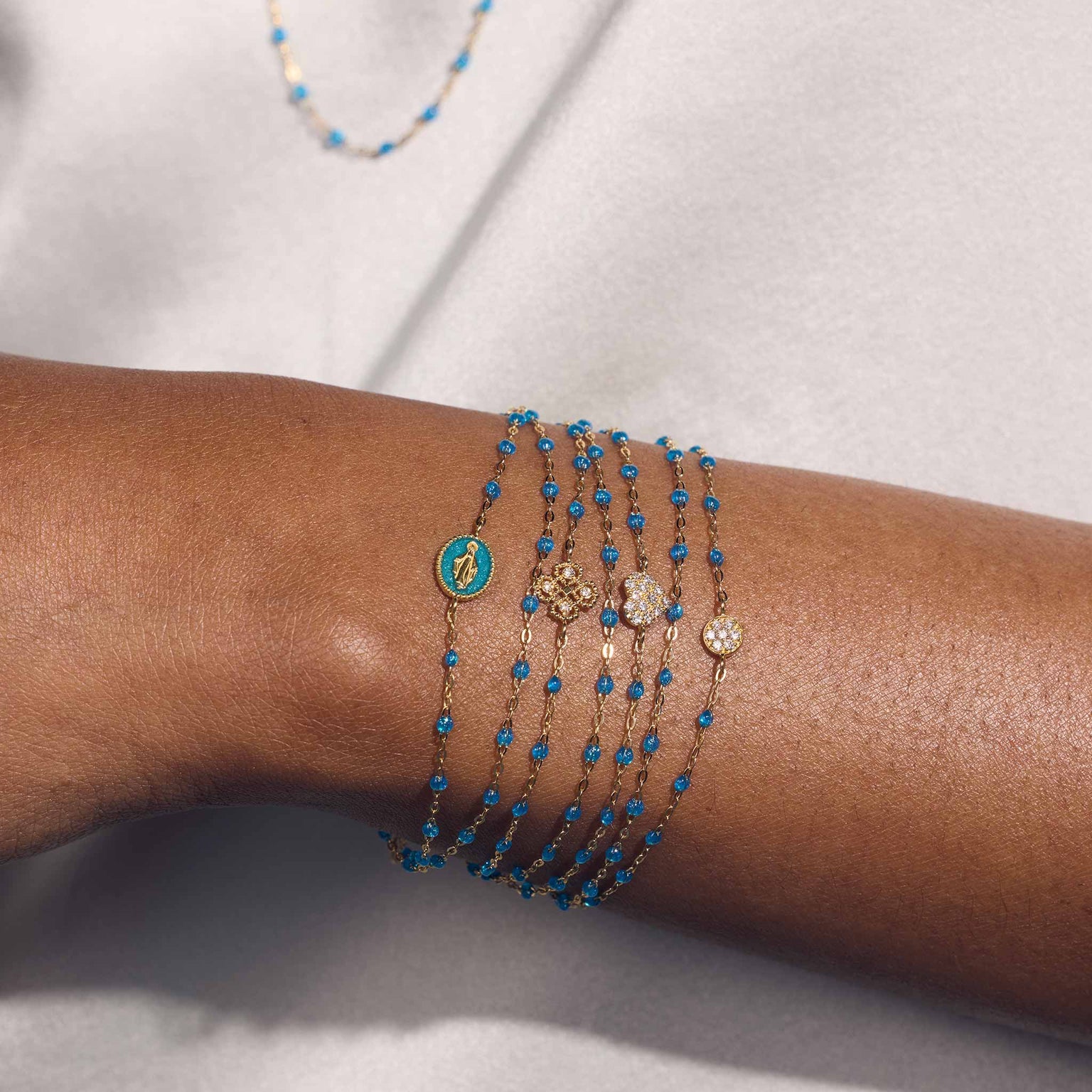 Photo du poignet d’une femme portant des bracelets Gigi Clozeau de la nouvelle couleur azur.