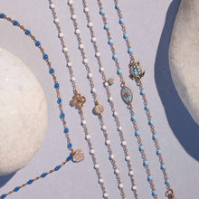 Photo de nature morte de plusieurs bracelets et d’un collier Gigi Clozeau posés.