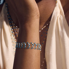 Photo du poignet d’une femme portant différents bracelets Gigi Clozeau.