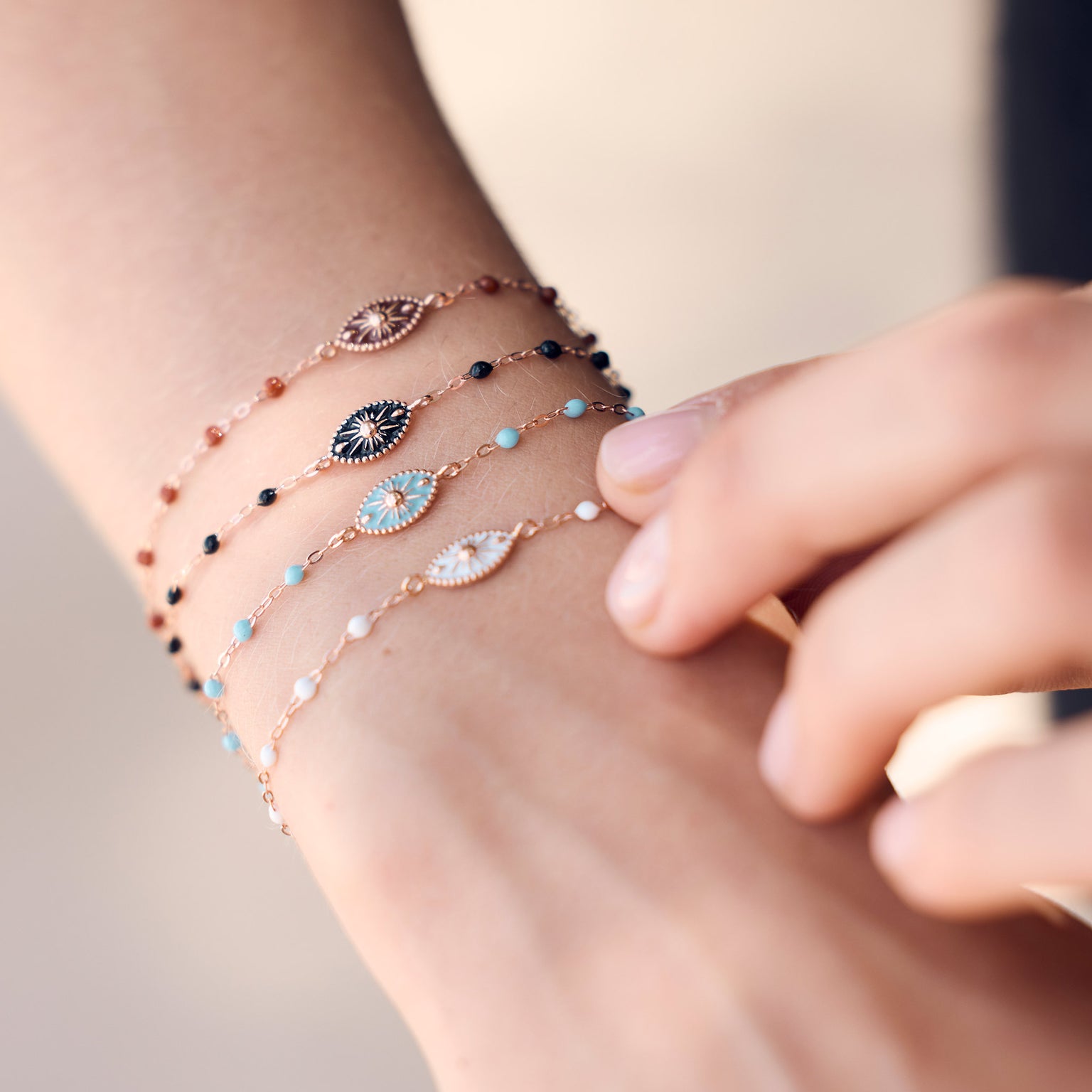 Photo du poignet d’une femme portant des bracelets de la collection Karma Gigi Clozeau de différentes couleurs.