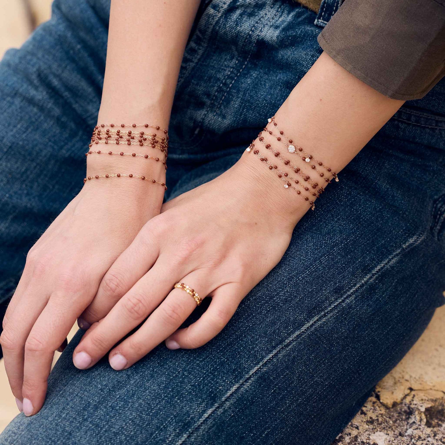 Photo des mains d’une femme portant à ses poignets des bracelets Gigi Clozeau de couleur moka.