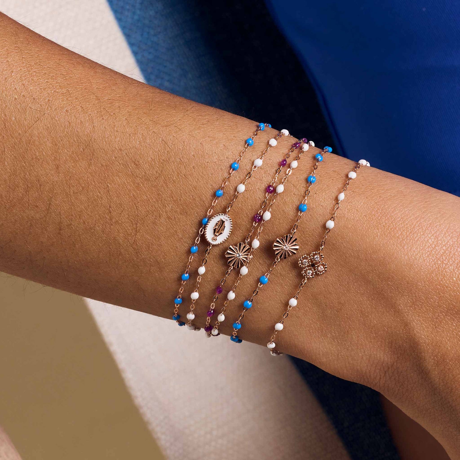 Photo du poignet d'une femme portant différent bracelets Gigi Clozeau. 