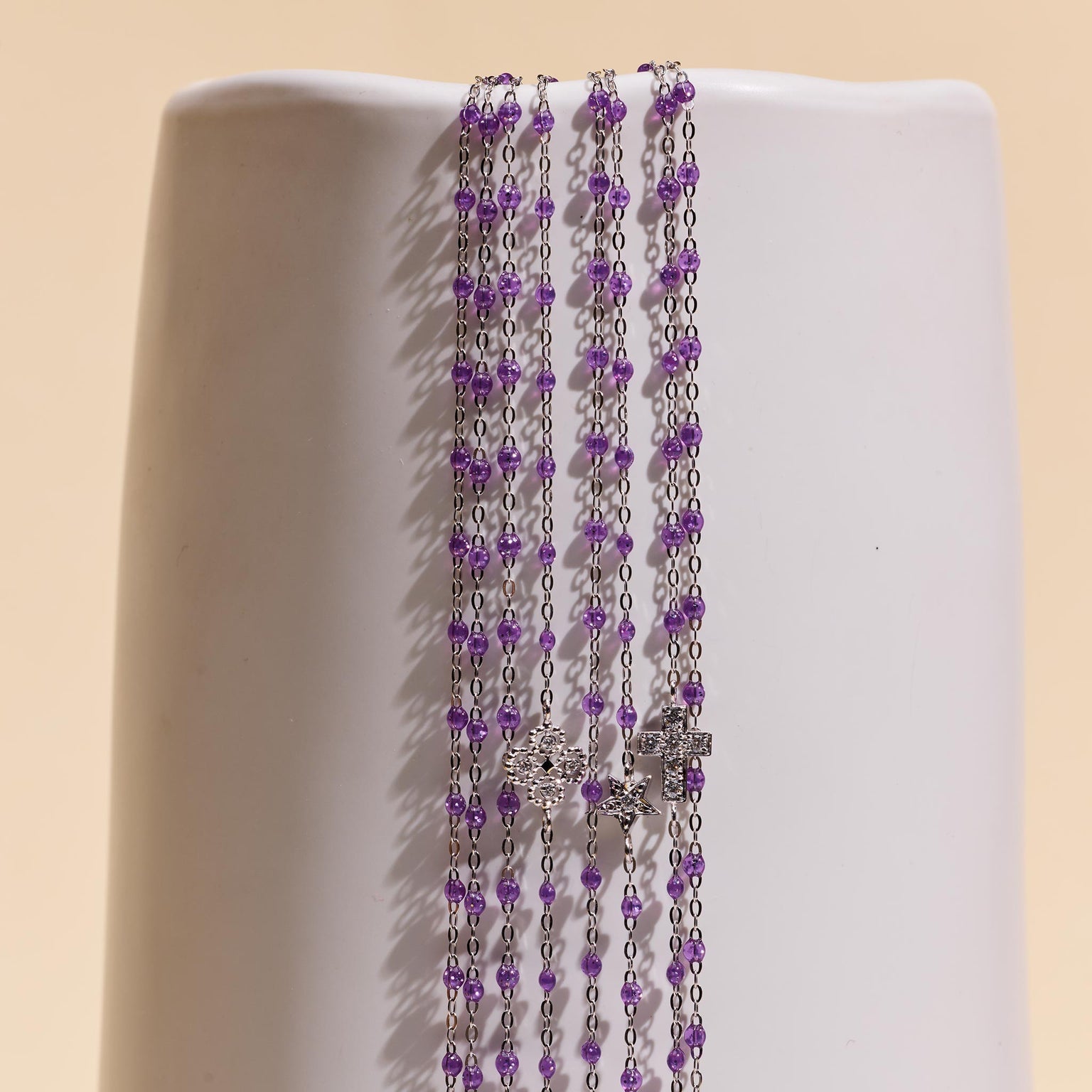 Photo de plusieurs bijoux Gigi Clozeau en or blanc couleur galaxy posés sur un vase.