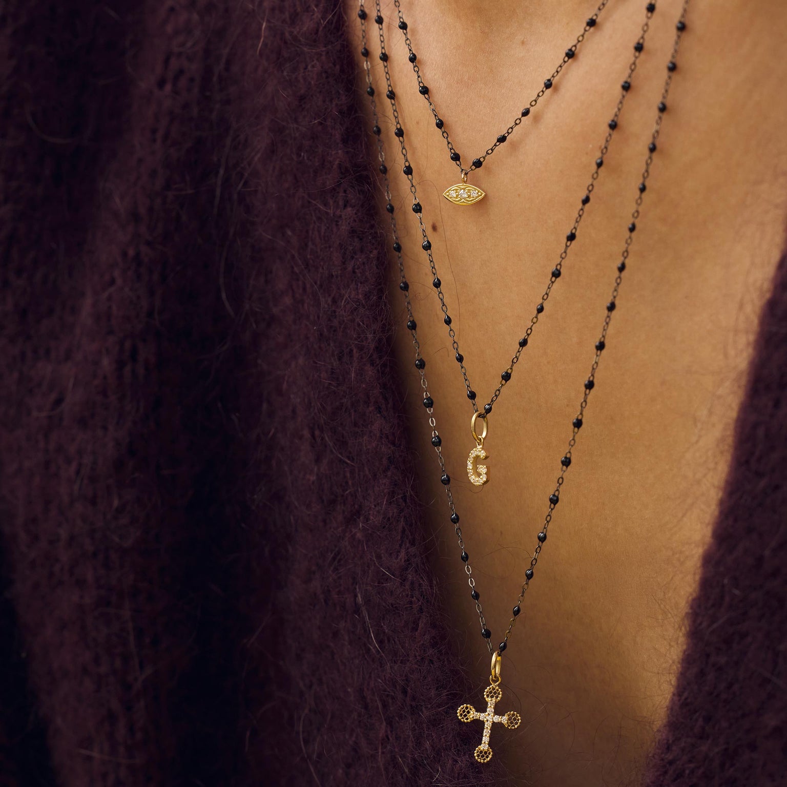Décolleté d’une femme portant des colliers en or noir Gigi Clozeau.