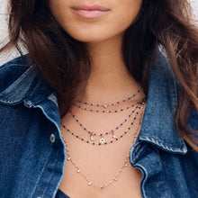Photo du cou d’une femme portant des colliers Gigi Clozeau de couleur bleue.