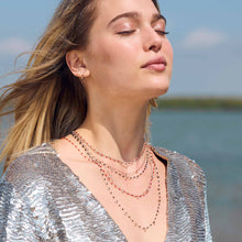 Photo d’une femme portant plusieurs colliers de différentes couleurs et modèles de Gigi Clozeau.