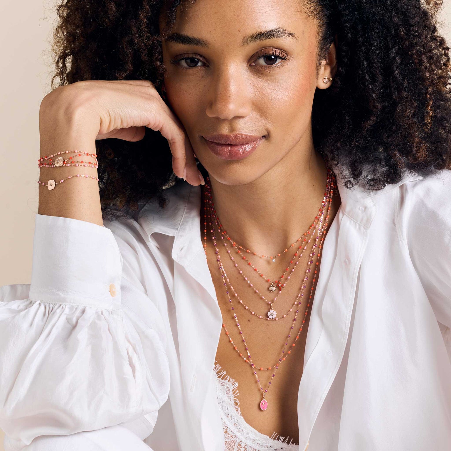 Photo d'une femme portant autour de son cou des colliers et des pendentifs Gigi Clozeau et autour de son poignet des bracelets Gigi Clozeau